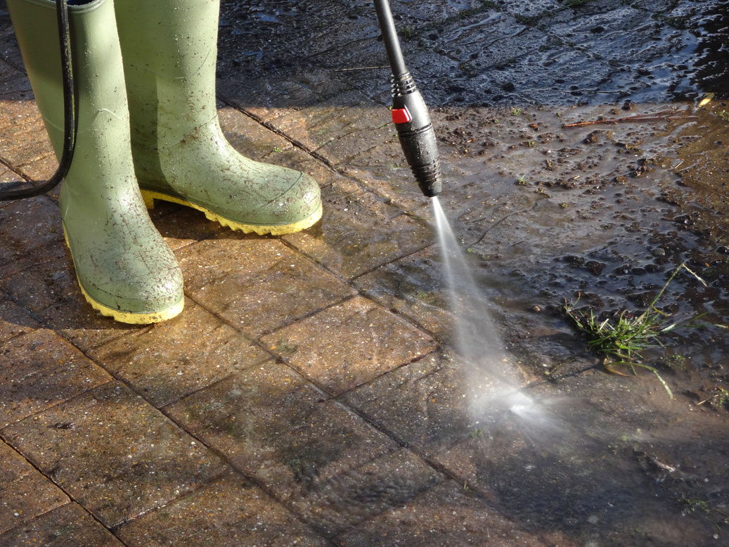 Image of boy with powerwasher / pressure-washing hose, washing block-paved drive